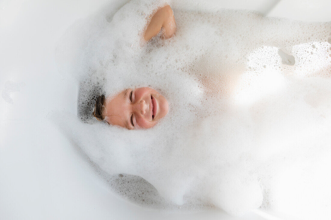 Boy (8-9) in bubble bath