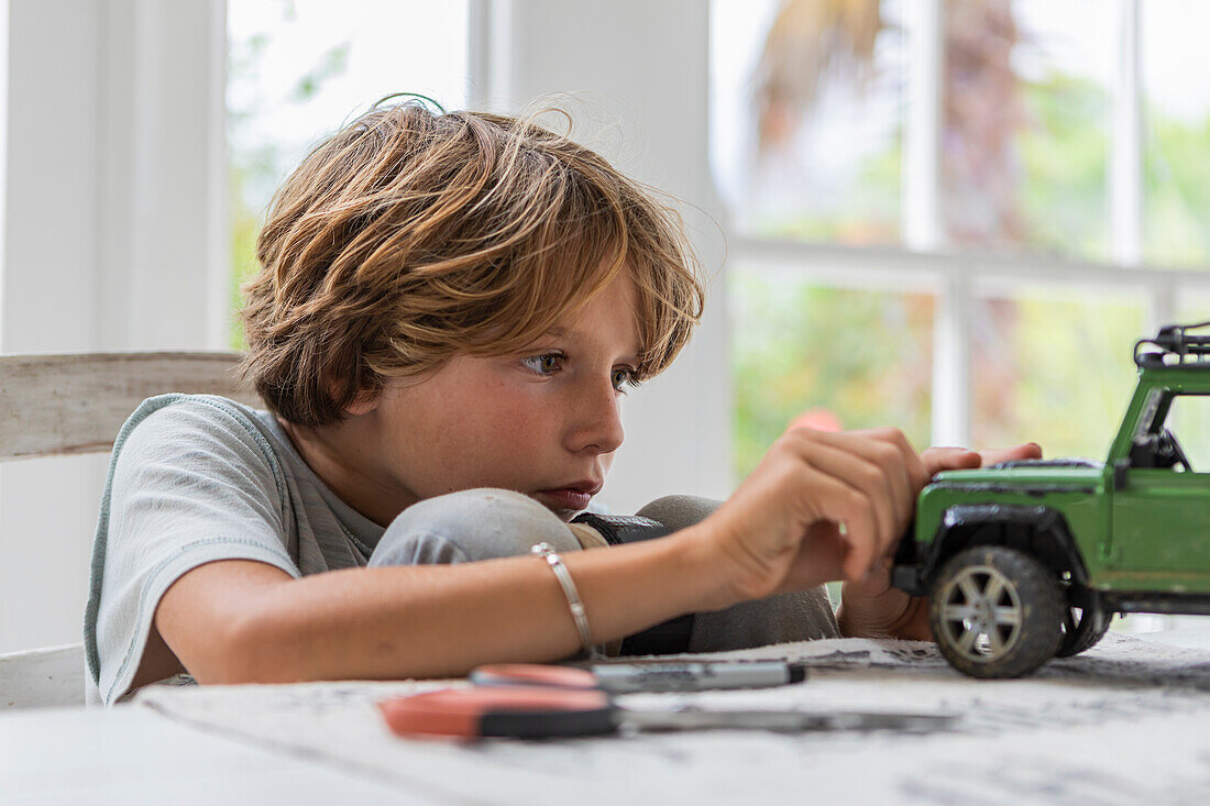 Boy (8-9) building car model toy