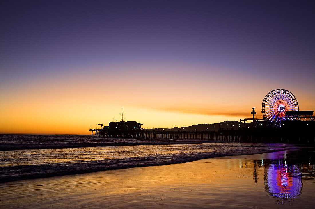 USA, California, Santa Monica. Ferris wheel and Santa Monica Pier at sunset
