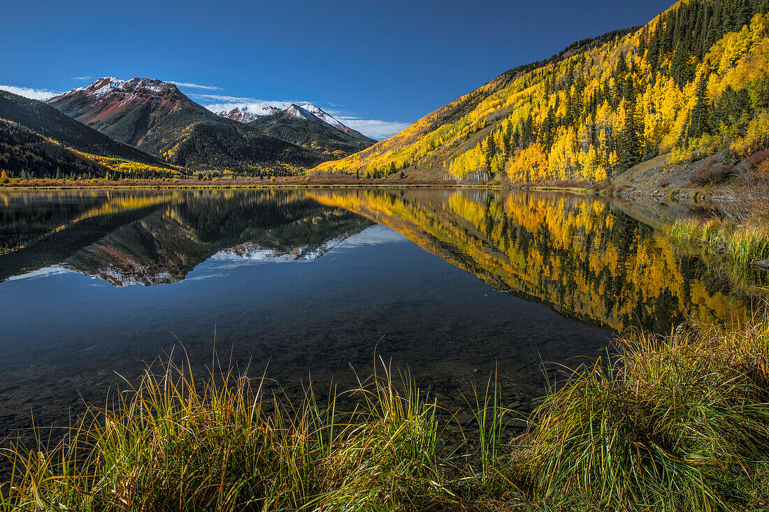 Red Mountain and autumn aspen trees reflected on Crystal Lake at sunrise, near Ouray, Colorado