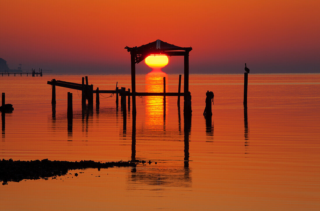 USA, Florida, Apalachicola, Sonnenaufgang an einem alten Bootshaus in der Apalachicola Bay.
