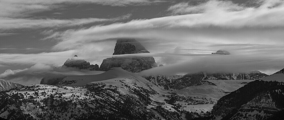 Black and white panoramic of Grand Teton, Middle Teton and Mount Owen seen from the west with cloud layers.