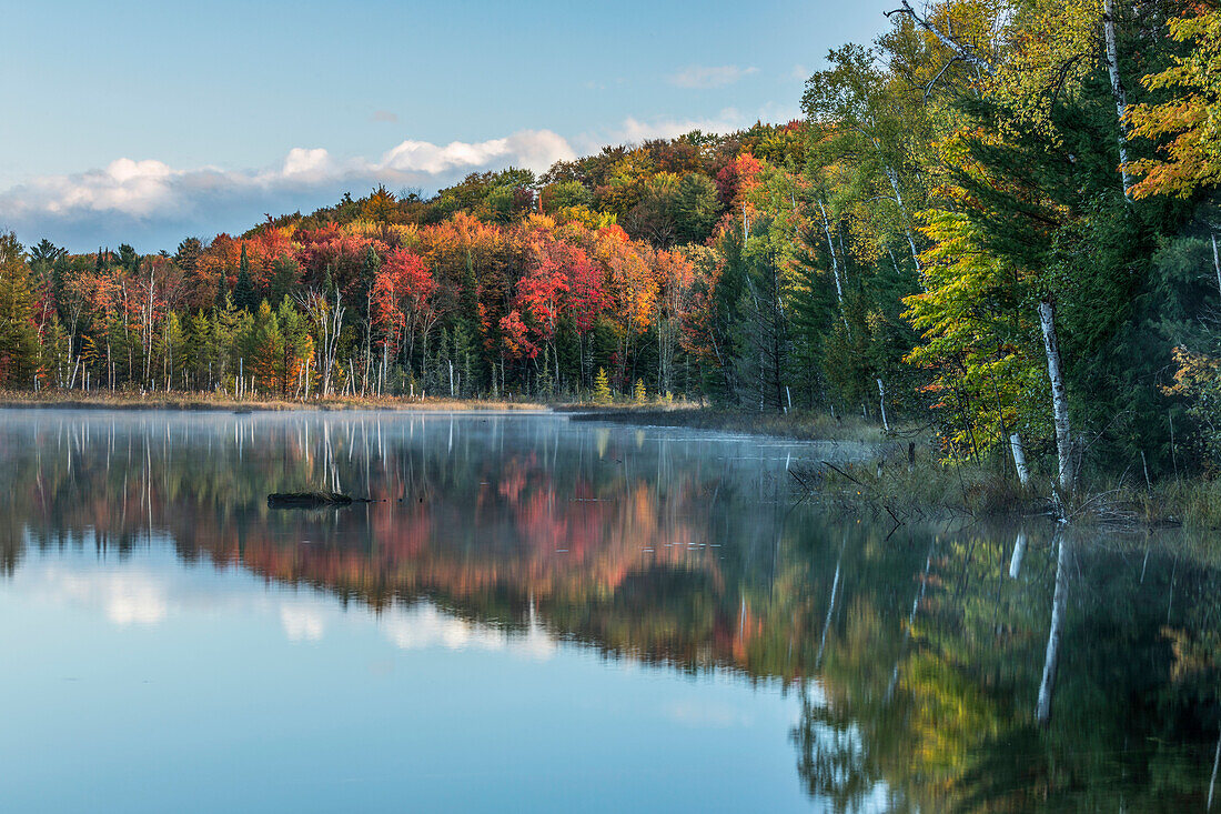 Autumn Colors and mist reflecting on Council Lake at sunrise, Hiawatha National Forest, Upper Peninsula of Michigan.