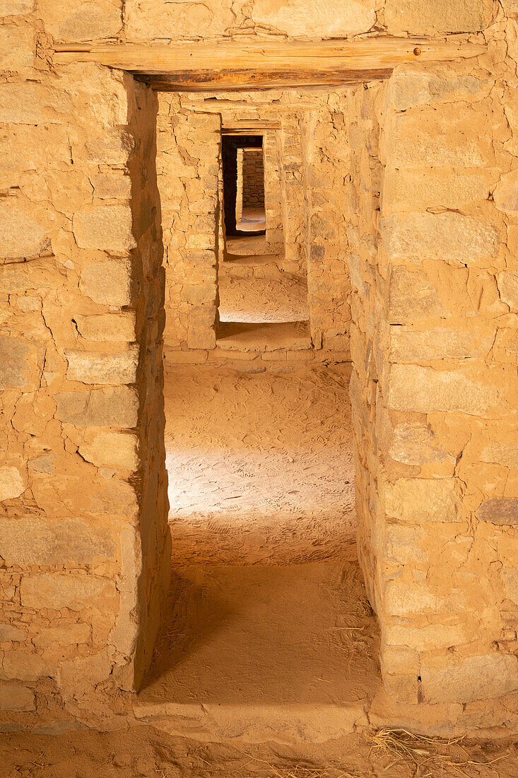 USA, Neu-Mexiko. Aztec Ruins National Monument, Sonnenlicht erhellt Räume und mehrere Türöffnungen mit Steinmauerwerk in der West Ruin.