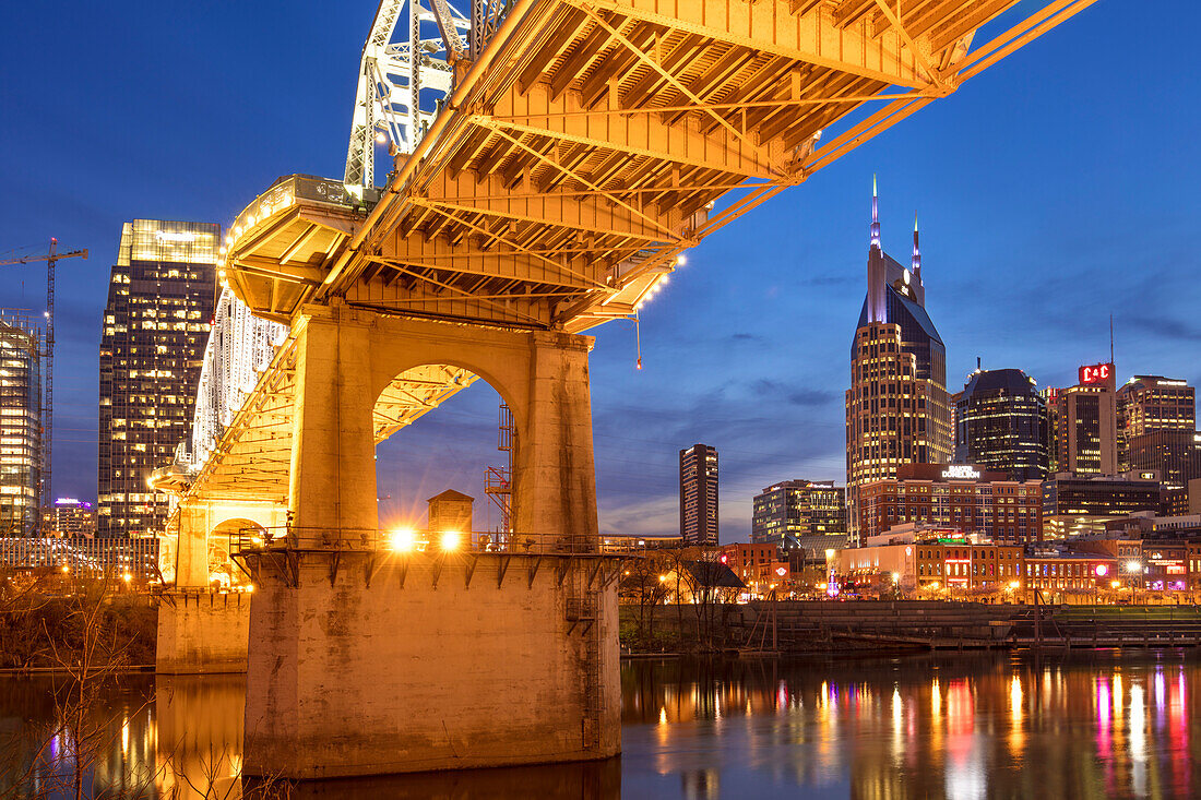 Dämmerung unter der John-Seigenthaler-Fußgängerbrücke über den Cumberland River mit der Skyline von Nashville, Tennessee, USA