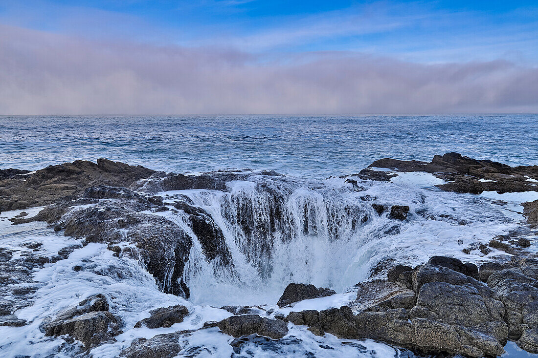 Thor's Well with surf cascading into the well along the Oregon coastline