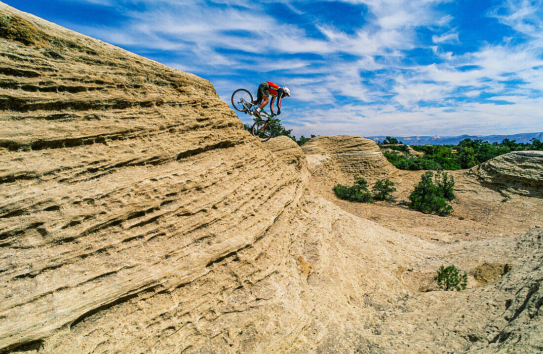 Mountainbiker balanciert zwischen Mut und Gefahr und versucht, einen Sturz am Red Rock zu vermeiden, Utah, USA. (MR)