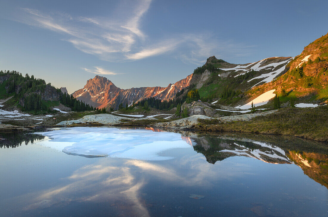 Partially thawed tarn, Yellow Aster Butte Basin. American Border Peak and Yellow Aster Butte are in the distance. Mount Baker Wilderness, North Cascades, Washington State