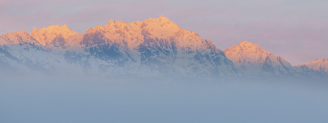 USA, Bundesstaat Washington, Mount Constance. Nebliges Sonnenaufgangspanorama eines Berges