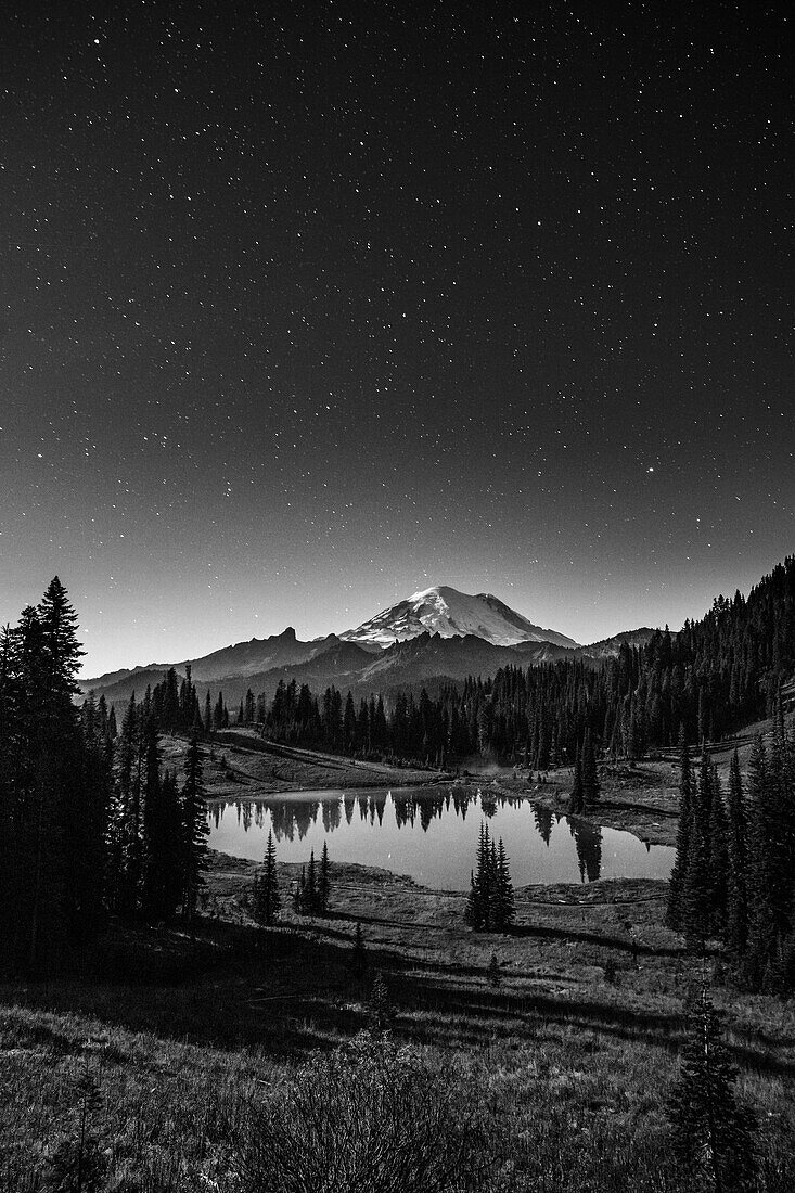 USA, Bundesstaat Washington, Mount Rainier National Park. Mount Rainier und Tipsoo Lake im Sternenlicht.