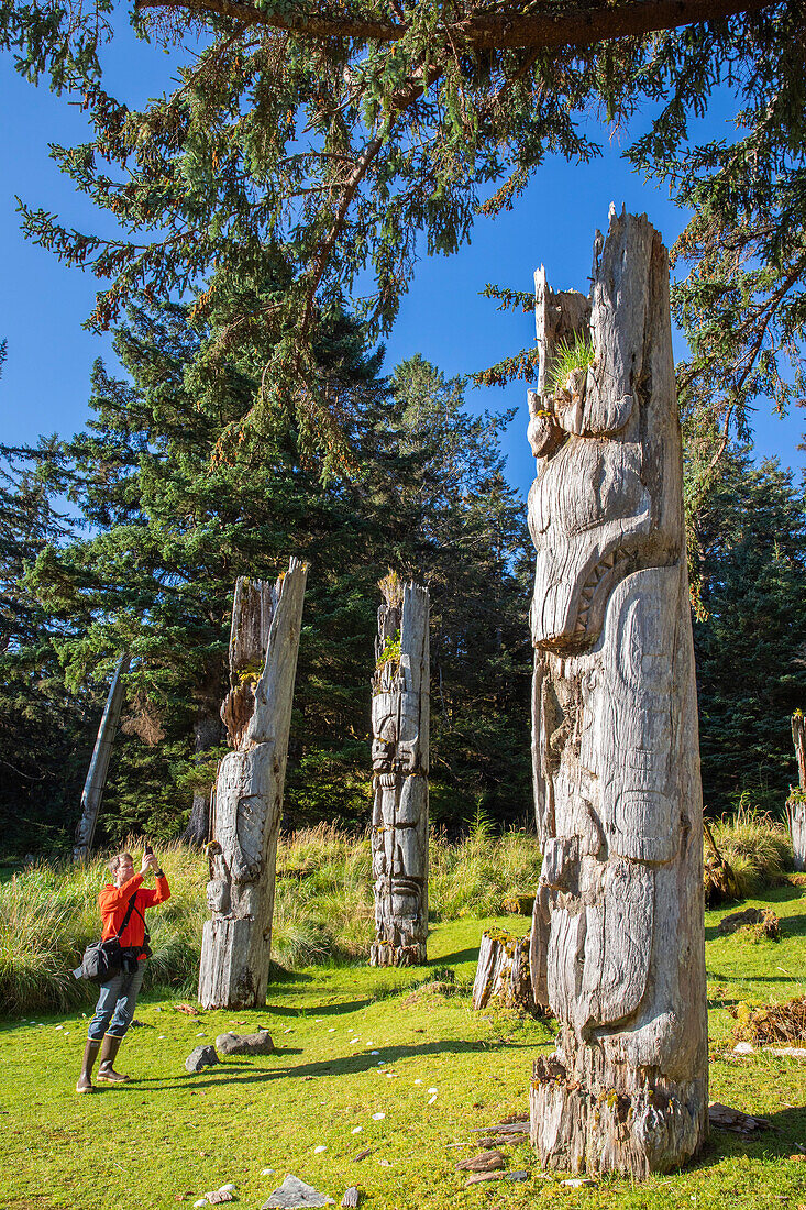 Fotograf mit Totempfahl in der UNESCO-Welterbestätte SGang Gwaay, Haida Gwaii, British Columbia, Kanada, Nordamerika
