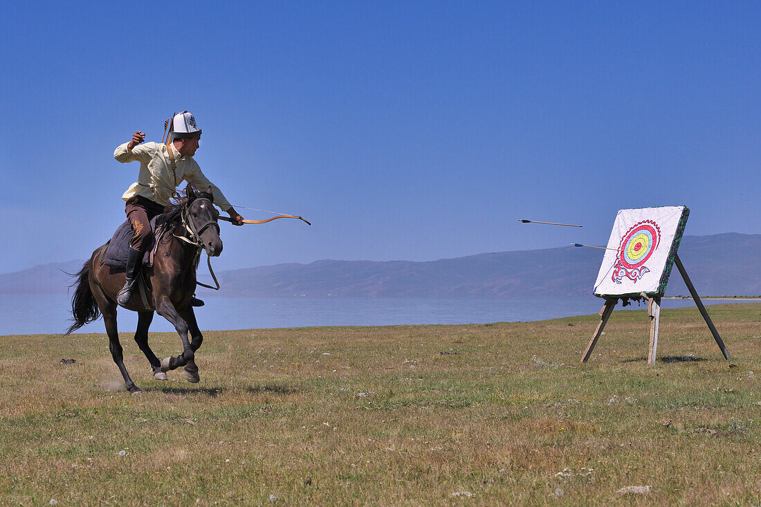 Kirgisischer Nomade schießt im Galopp Pfeile auf eine Zielscheibe, Song-Kol-See, Region Naryn, Kirgisistan, Zentralasien, Asien