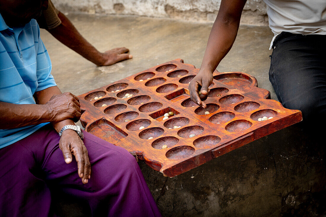 Men playing the famous Bao board game in the street, Stone Town, Zanzibar, Tanzania, East Africa, Africa