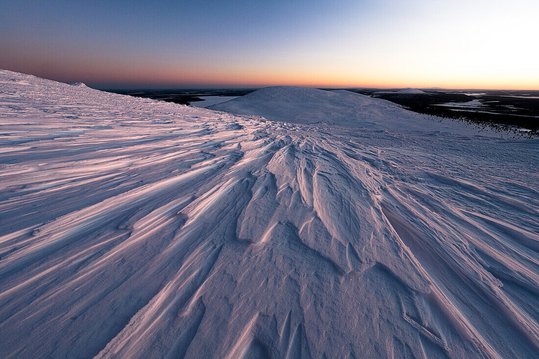 Eisplatten bedecken die verschneiten Berge in der Abenddämmerung, Pallas-Yllastunturi-Nationalpark, Muonio, Lappland, Finnland, Europa