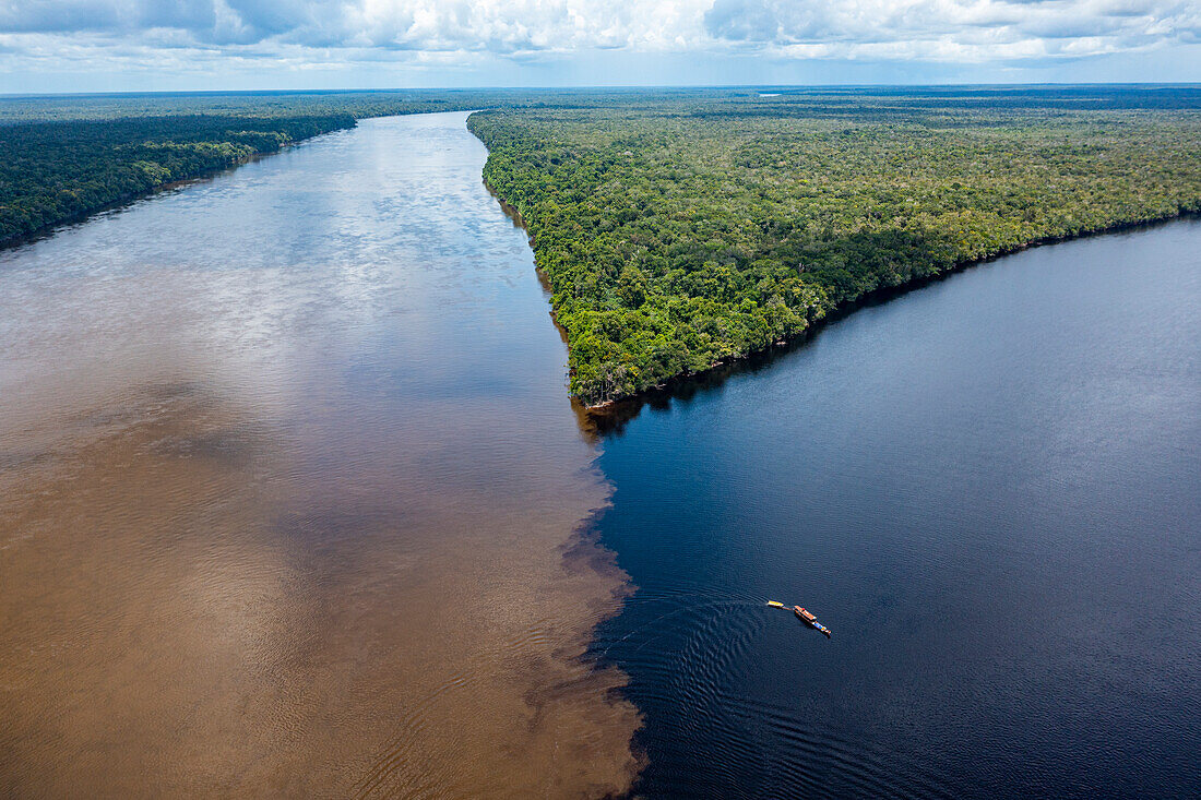 Kleines Boot am Zusammenfluss von Casiquiare und schwarzem Pasimoni-Fluss, im tiefen Süden von Venezuela, Südamerika