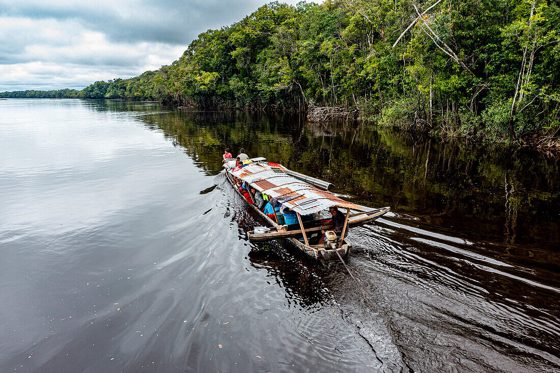 Illegal miners on their boat on the black Pasimoni River, in the deep south of Venezuela, South America