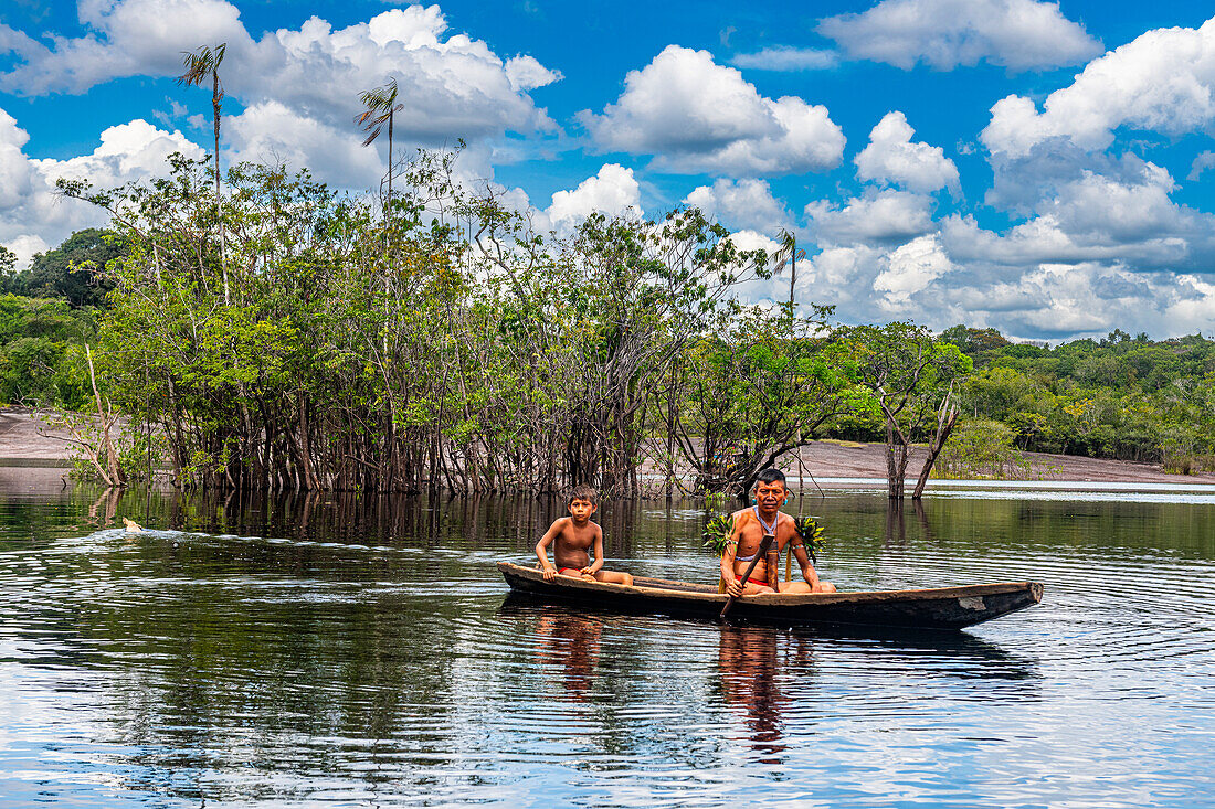 Vater und Sohn vom Stamm der Yanomami in einem Kanu, Südvenezuela, Südamerika