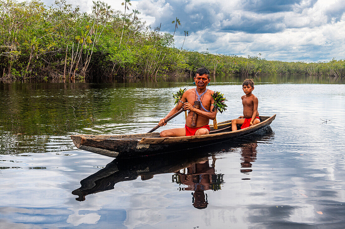 Vater und Sohn vom Stamm der Yanomami in einem Kanu, Südvenezuela, Südamerika