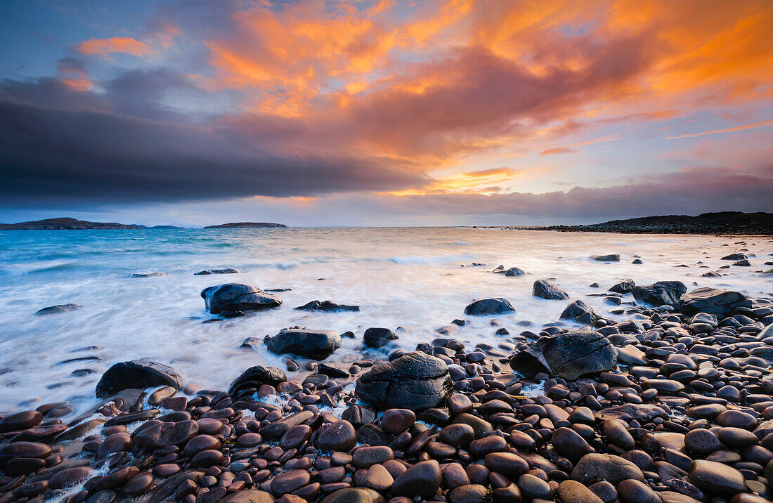 Steinstrand an der Reiff Bay mit den Summer Isles im Hintergrund während eines farbenprächtigen Sonnenuntergangs an der Küste des nordwestlichen Schottlands, Highland, Schottland, Vereinigtes Königreich, Europa