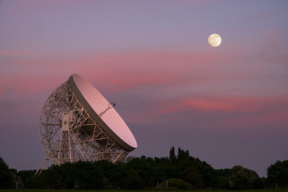 Das Lovell Mark I Riesenradioteleskop bei Nacht mit perfekter Ausrichtung auf den Vollmond, Jodrell Bank, Cheshire, England, Vereinigtes Königreich, Europa