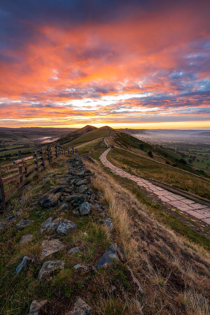 The Great Ridge und Pfad bei Sonnenaufgang mit feurigem Himmel, The Peak District, Derbyshire, England, Vereinigtes Königreich, Europa