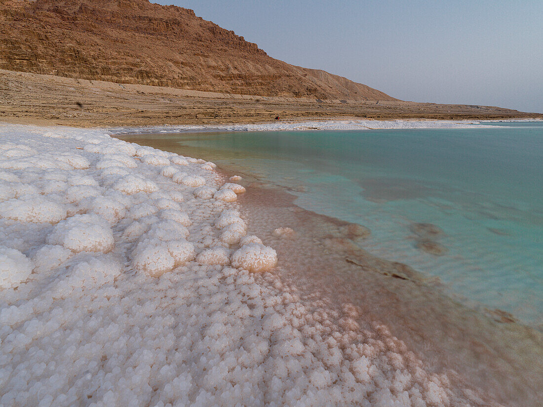 Salziges Ufer und türkisfarbenes Wasser des Toten Meeres, Jordanien, Naher Osten