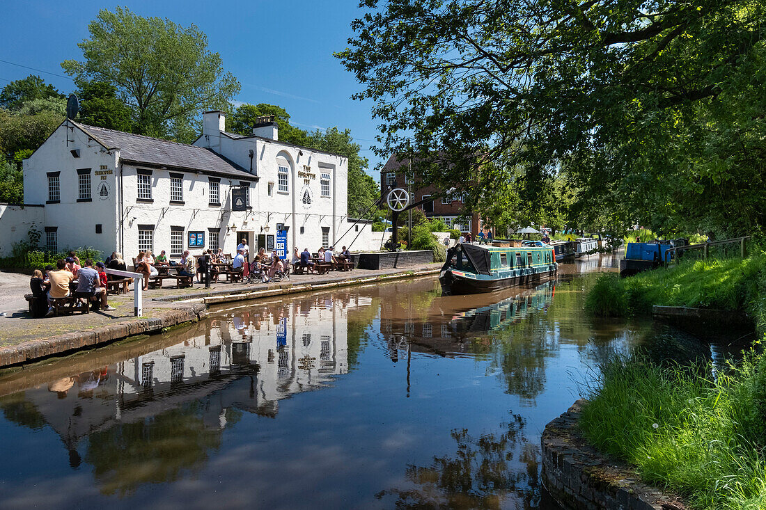 A canal narrowboat approaches the Shroppie Fly Inn, Shropshire Union Canal, Audlem, Cheshire, England, United Kingdom, Europe