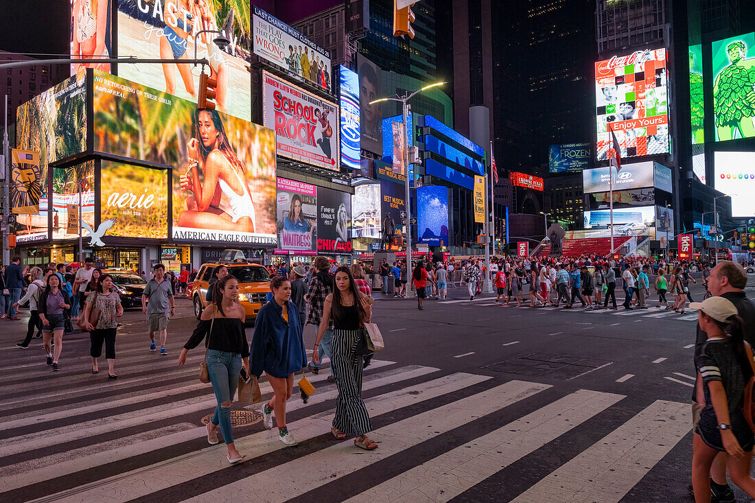 Pedestrians crossing Times Square at night, Manhattan, New York, United States of America, North America