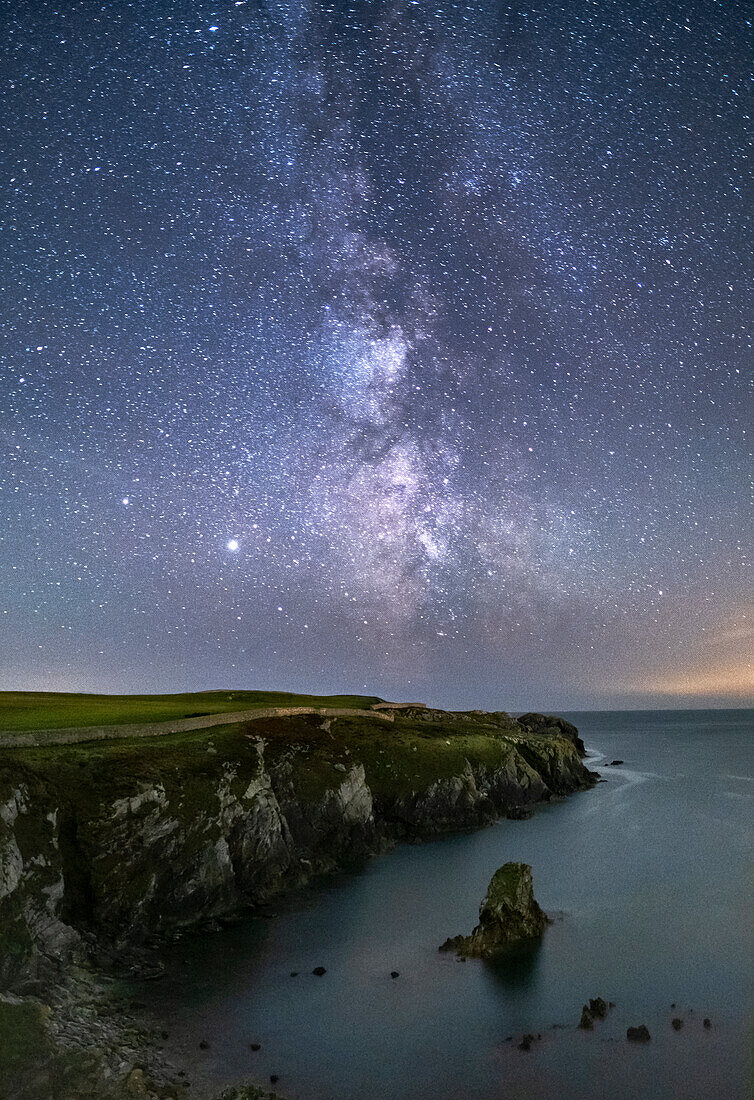 The Milky Way and night sky over Gwenfaens Pillar, Porth Saint, near Rhoscolyn, Anglesey, North Wales, United Kingdom, Europe