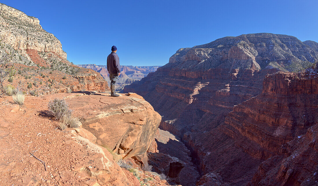 Ein Wanderer blickt von einer Klippe im Hermit Canyon am Grand Canyon, Grand Canyon National Park, UNESCO-Weltnaturerbe, Arizona, Vereinigte Staaten von Amerika, Nordamerika