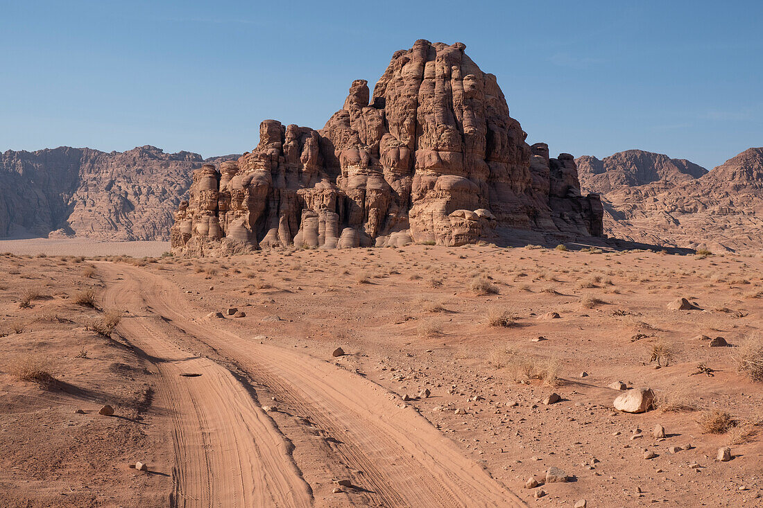 Geländewagen-Spuren im Sand von Wadi Rum, die zu einem felsigen Berg führen, Wadi Rum, Jordanien, Naher Osten