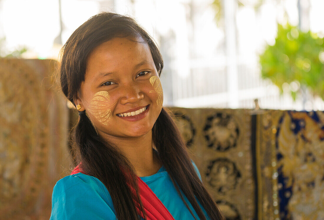 Junge birmanische Frau mit Blättern, die mit Thanaka auf ihre Wangen gemalt sind, Sandamuni-Pagode, Mandalay, Myanmar (Birma), Asien