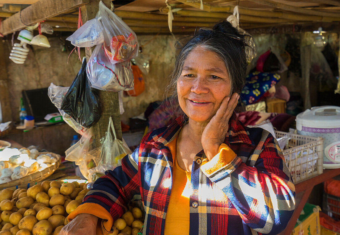 Ältere Frau mit Hand auf der Wange und lächelnd auf dem Markt, Hsipaw, Shan-Staat, Myanmar (Birma), Asien