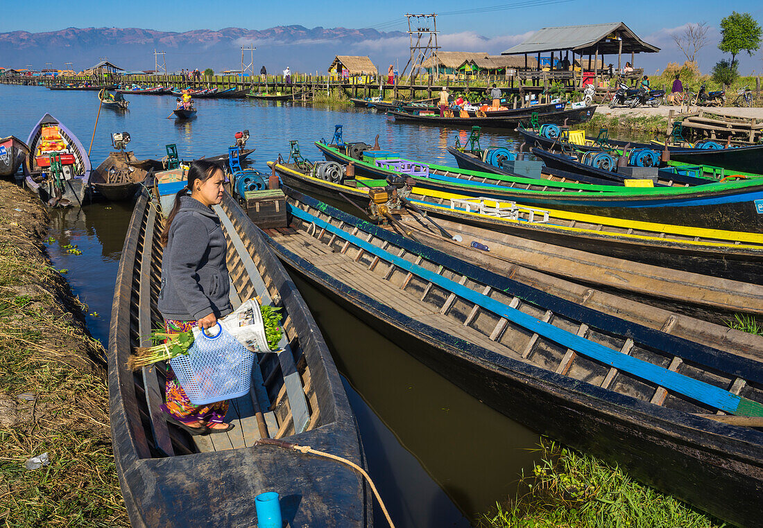 Frau kehrt nach dem Einkaufen zum Boot zurück, Bootshafen, Inle-See, Shan-Staat, Myanmar (Birma), Asien