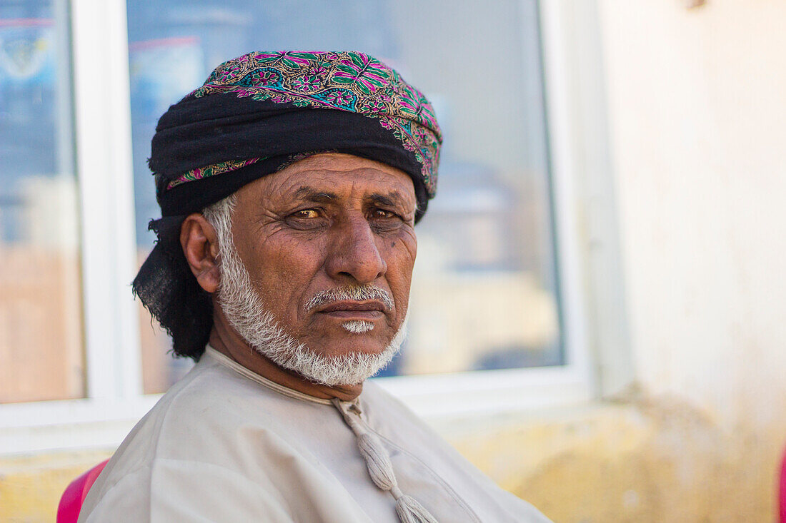 Porträt eines omanischen Mannes mit Kopfbedeckung, der in die Kamera schaut, Hasik, Dhofar Governorate, Oman, Mittlerer Osten