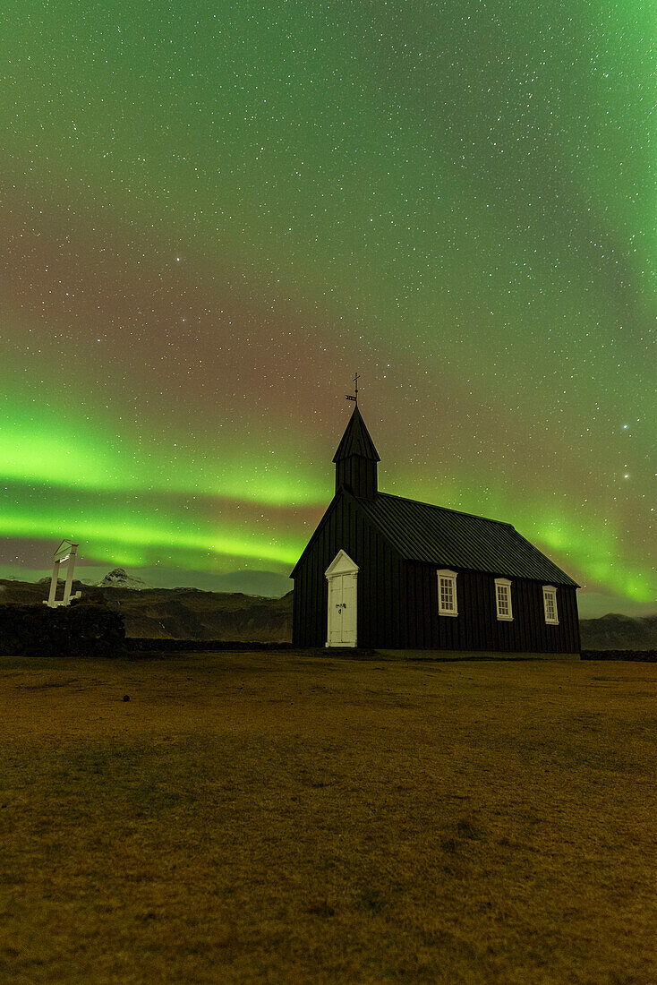 Ikonische schwarze Holzkirche Budakirkja unter den Nordlichtern (Aurora Borealis), Budir, Snaefellsness Halbinsel, Vesturland, Island, Polarregionen