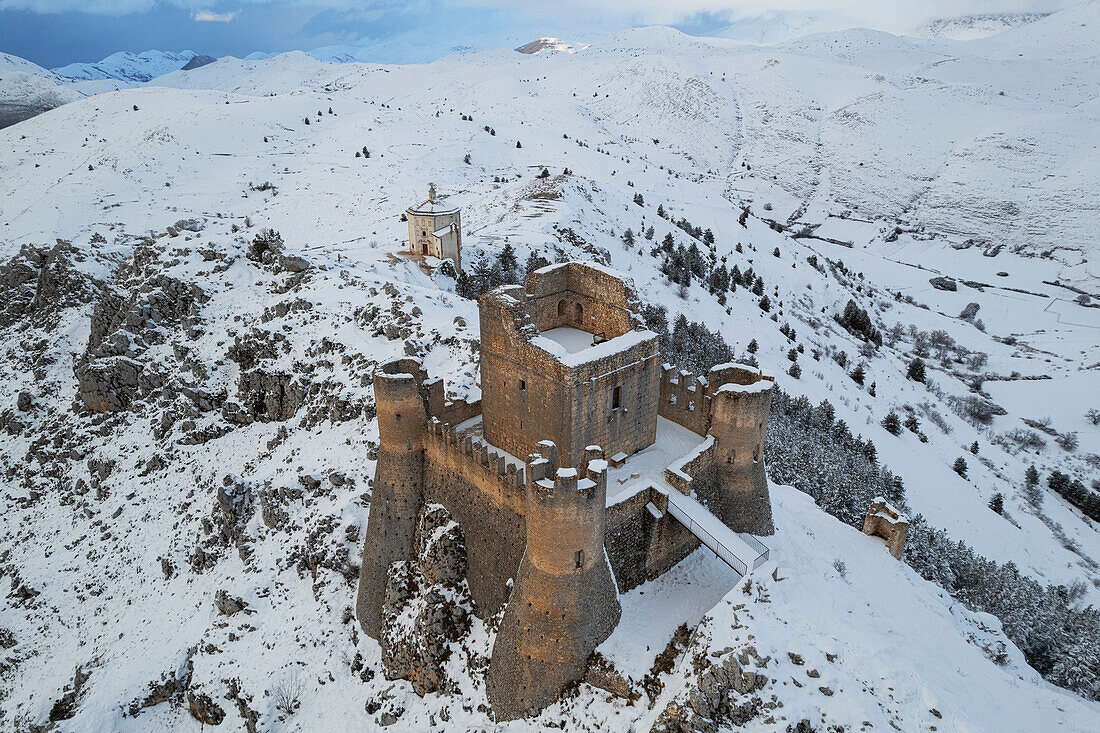 Close-up aerial view of the snow covered medieval castle of Rocca Calascio and the church of Santa Maria della Pieta? at dusk, Rocca Calascio, Gran Sasso e Monti della Laga National Park, Campo Imperatore, L'Aquila province, Abruzzo region, Italy, Europe