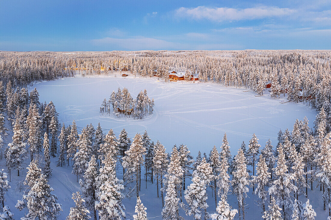 Aerial view of a tourist winter resort in the snow covered forest and the frozen lake in Kangos, Pajala, Norrbotten, Norrland, Lapland, Sweden, Scandinavia, Europe