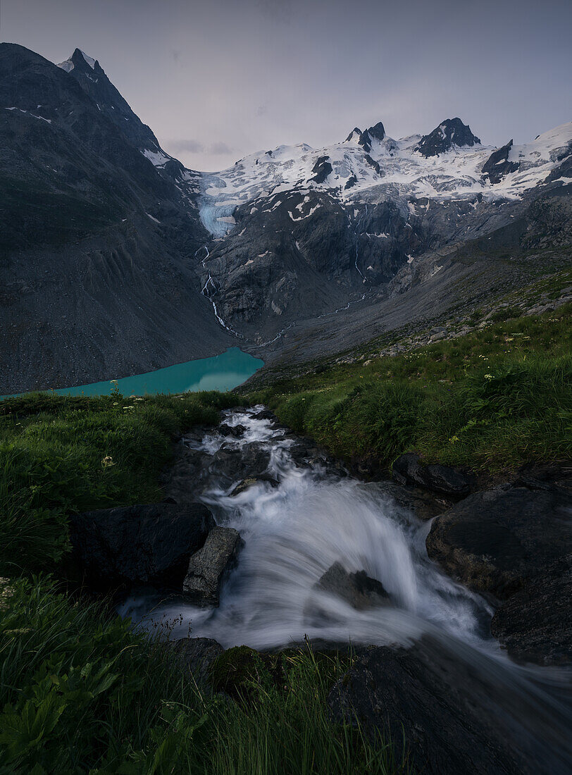 Bach vor einem massiven Gebirge und Gletschern in den Zentralalpen, Schweiz, Europa