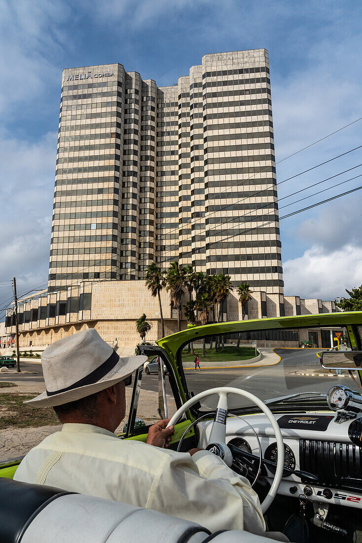 Fahrer mit Panamahut in grünem Chevrolet Oldtimer mit offenem Verdeck fährt durch die Stadt, Havanna, Kuba, Westindien, Karibik, Mittelamerika