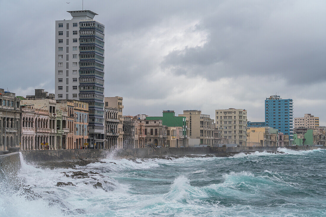 Storm waves batter the seafront Malecon with its faded grandeur stucco houses on Malecon, Havana, Cuba, West Indies, Caribbean, Central America