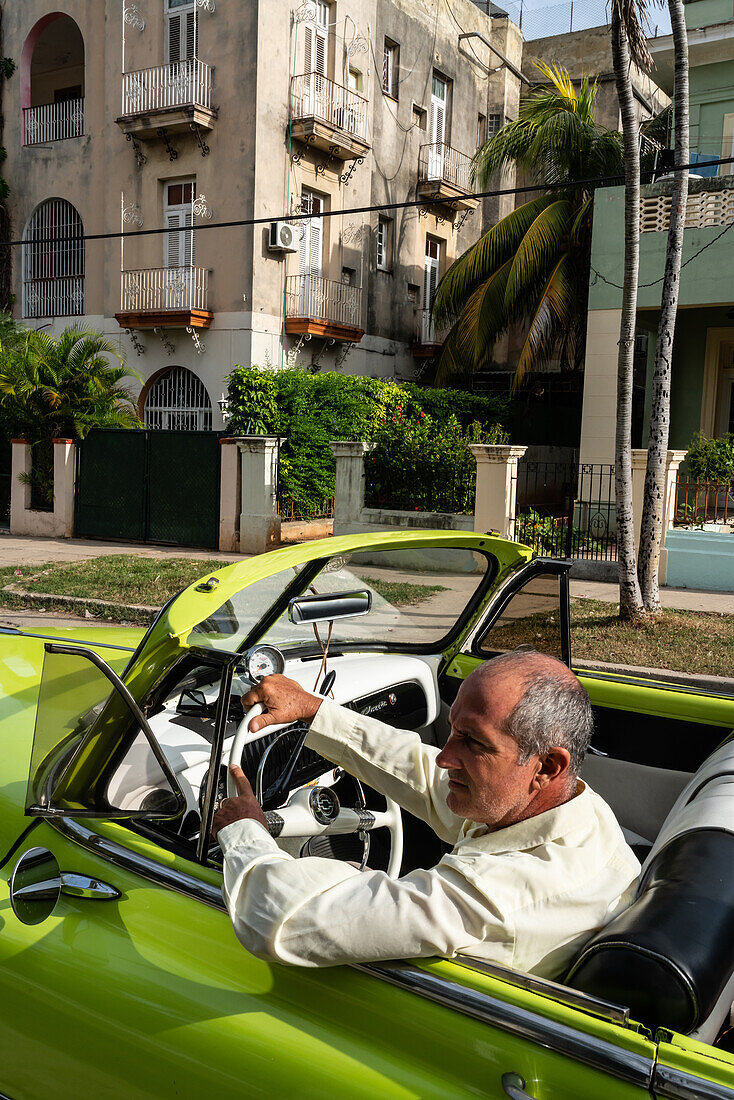 Fahrer in grünem Chevrolet Oldtimer mit offenem Verdeck in einem Vorort, Havanna, Kuba, Westindien, Karibik, Mittelamerika