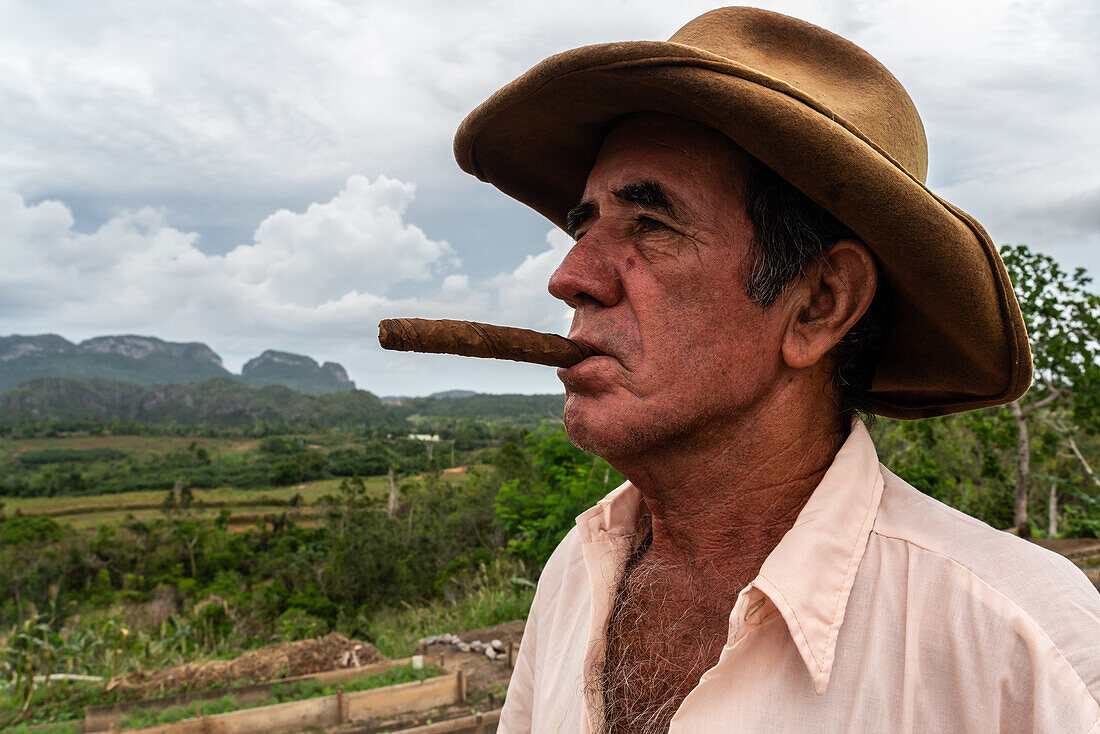 Tobacco plantation worker with cigar, on valley ridge, Vinales, Cuba, West Indies, Caribbean, Central America