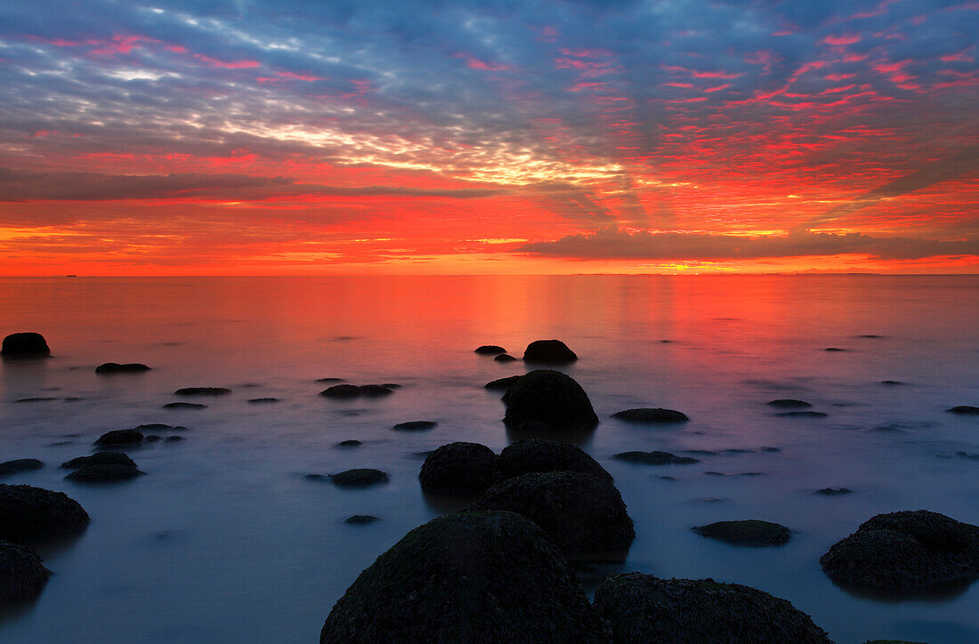 Mittsommer-Sonnenuntergang über The Wash, vom Strand von Hunstanton, North Norfolk, England, Vereinigtes Königreich, Europa