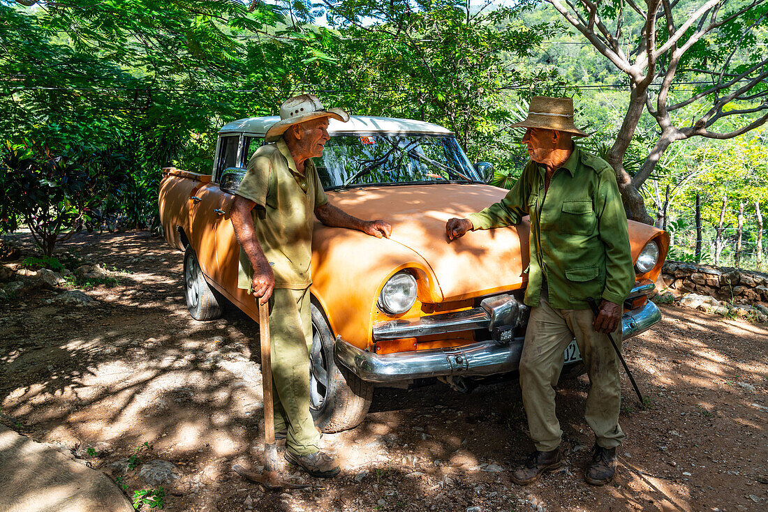 Landarbeiter und Cowboy diskutieren in einer Pause an einem alten, umgebauten Auto, in der Nähe von Trinidad, Kuba, Westindien, Karibik, Mittelamerika