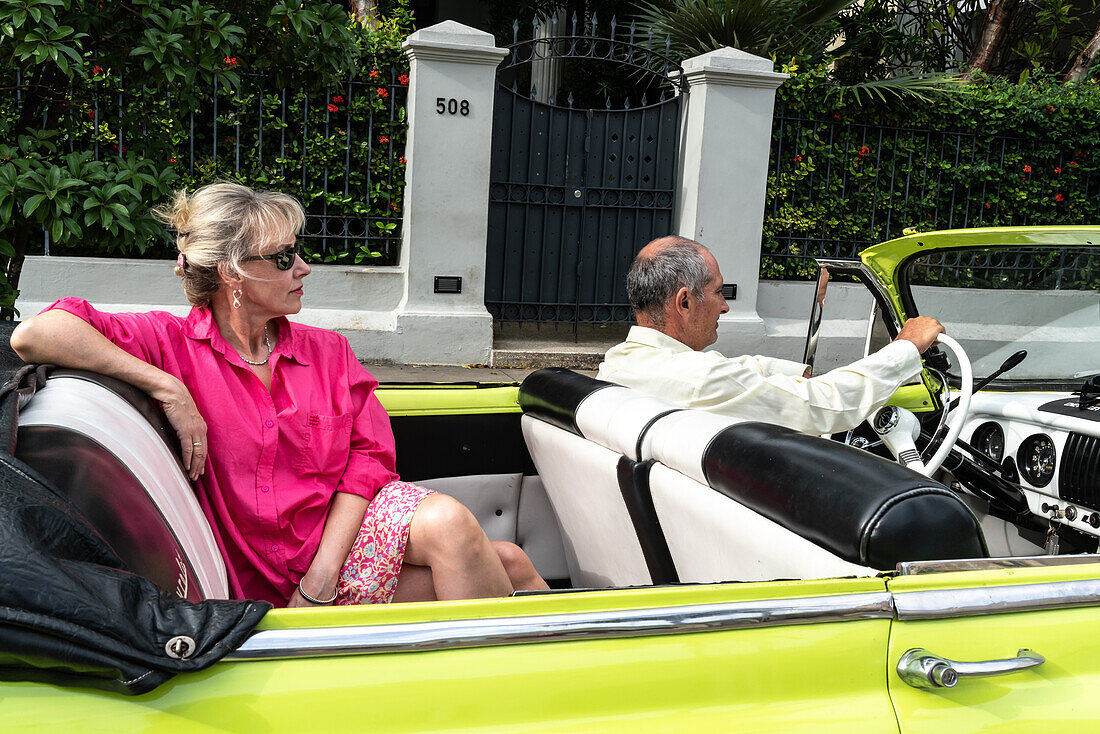 Attraktive westliche Touristin wird in einem offenen Chevrolet Oldtimer herumgefahren, Havanna, Kuba, Westindien, Karibik, Mittelamerika