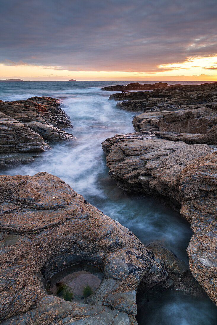 Sunset over the North Atlantic from the rocky Cornish seashore near Padstow, Cornwall, England, United Kingdom, Europe