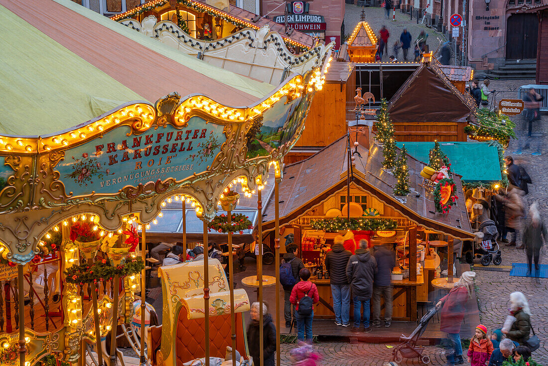 View of carousel and stalls of Christmas Market, at dusk, Roemerberg Square, Frankfurt am Main, Hesse, Germany, Europe