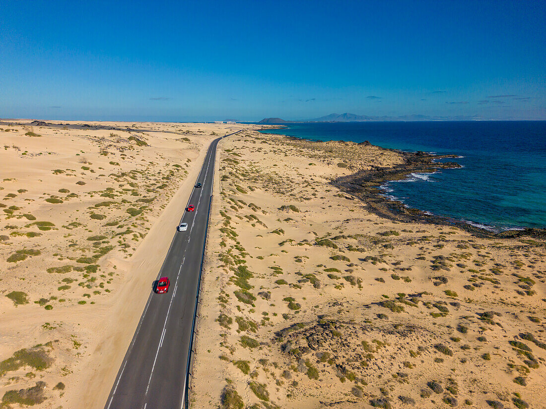 Luftaufnahme einer Straße durch Sanddünen mit Blick auf den Atlantischen Ozean, Corralejo Natural Park, Fuerteventura, Kanarische Inseln, Spanien, Atlantik, Europa