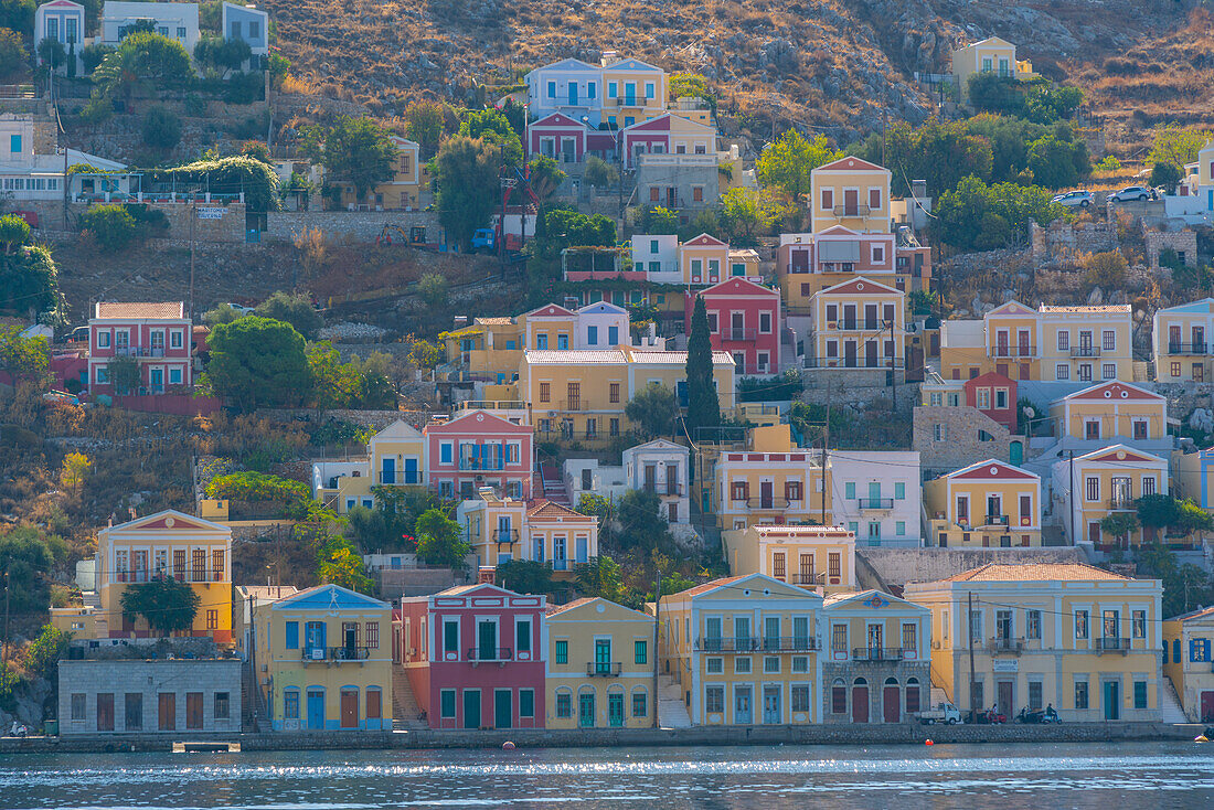 View of clourful houses overlooking harbour of Symi Town, Symi Island, Dodecanese, Greek Islands, Greece, Europe